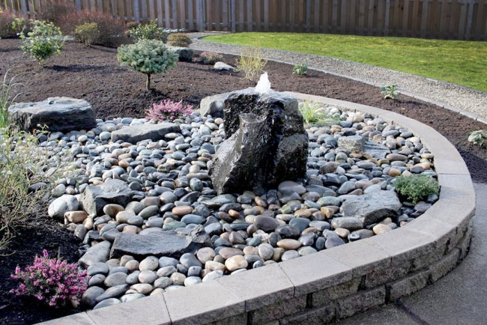 Bubbling boulder fountain in landscaped dry creek bed. Bubbling boulder fountain in landscaped dry creek bed.